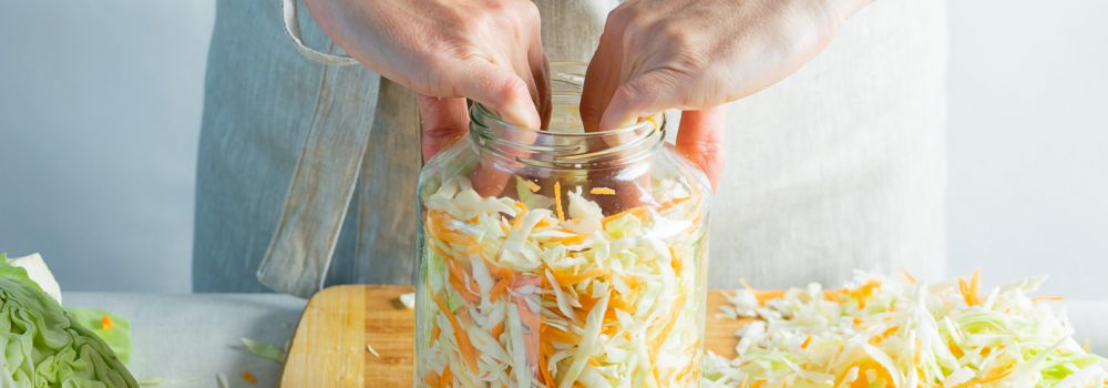 The preparation process fermentation preservation Sauerkraut on a light background. Natural rustic style. Canned food The preparation process fermentation preservation Sauerkraut on the table a light background. Processing of the autumn harvest. Natural rustic style. Canned vegetarian healthy food concept.